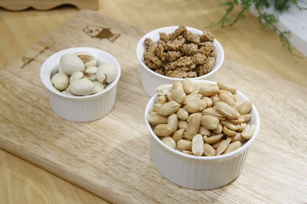 Noix d'amandes crues sur fond blanc, amandes pour chien